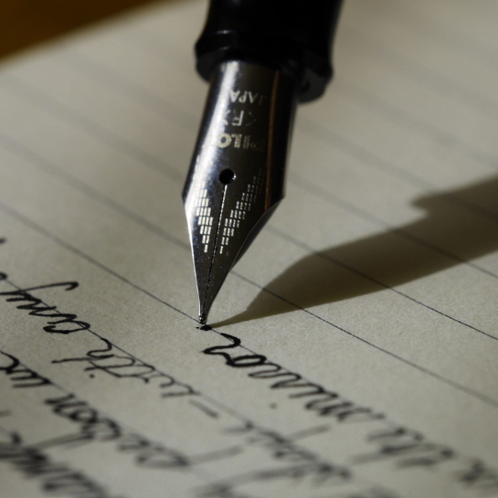 A pen scratches on a piece of paper